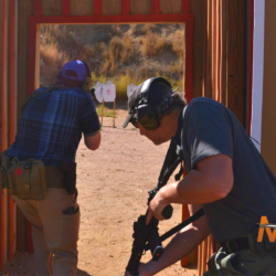 Participants wearing tactical gear out in the field in a rifle firearms training class in Colorado